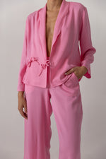 A model is wearing a pink suit by deidei on a white backdrop