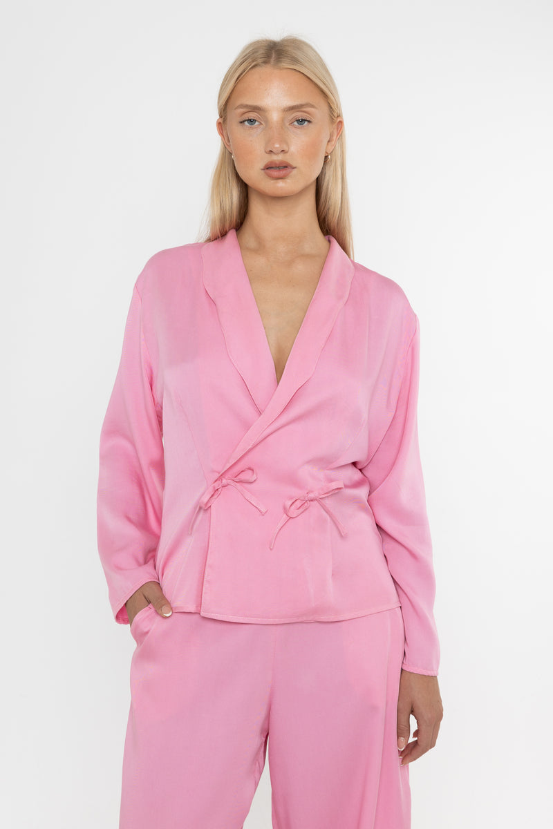 Woman wearing a Deidei Malala pink tencel trouser suit on a white background