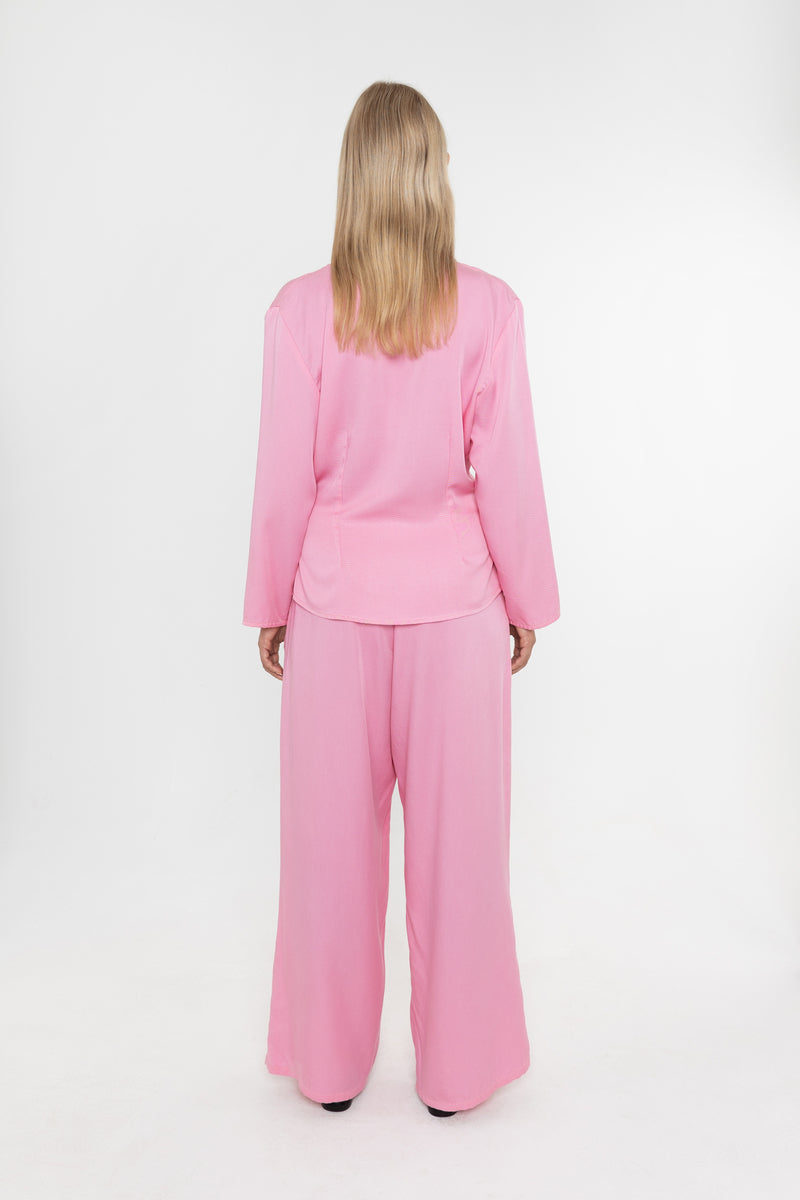 Woman wearing a Deidei Malala pink tencel trouser suit on a white background