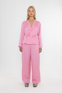 Woman wearing a Deidei pink trouser suit on a white background