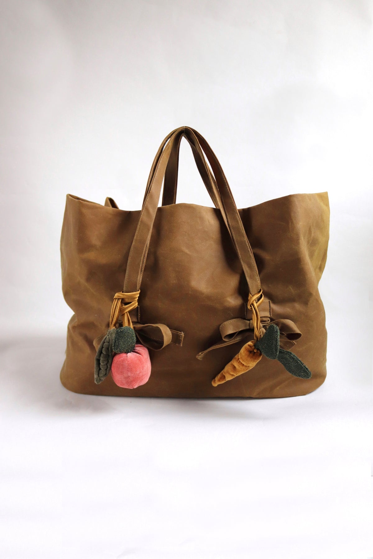 Brown tote bag with decorative elements on a white background