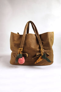 Brown tote bag with decorative elements on a white background