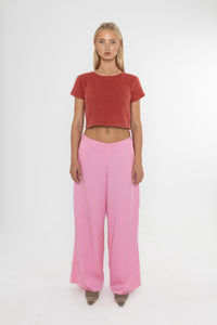 Woman wearing a red angora cropped top and Deidei Ella pink tencel wide-leg trousers on a white background