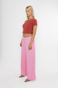 Woman wearing a red angora cropped top and Deidei Ella pink tencel wide-leg trousers on a white background