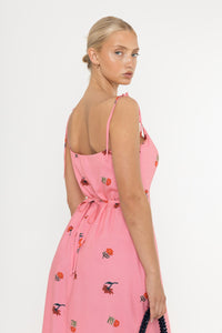 Close up of woman wearing a Deidei Emmeline midi slip dress with pink floral rose print on a white background