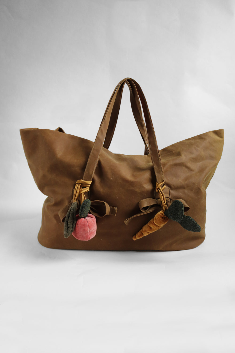 Brown tote bag with bag charms elements on a white background