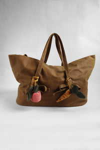 Brown tote bag with bag charms elements on a white background