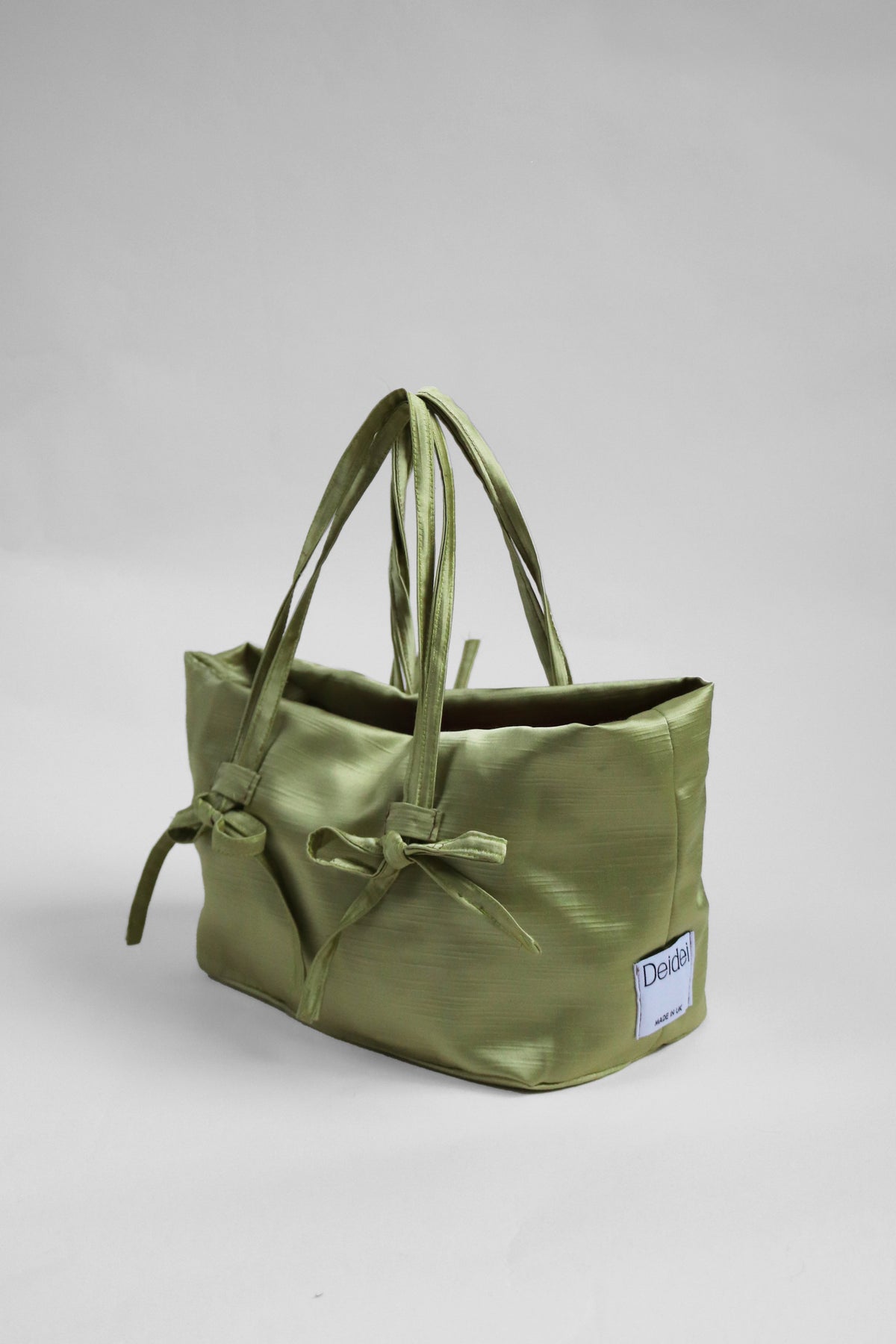 Green tote bag with bow details and Deidei brand label 